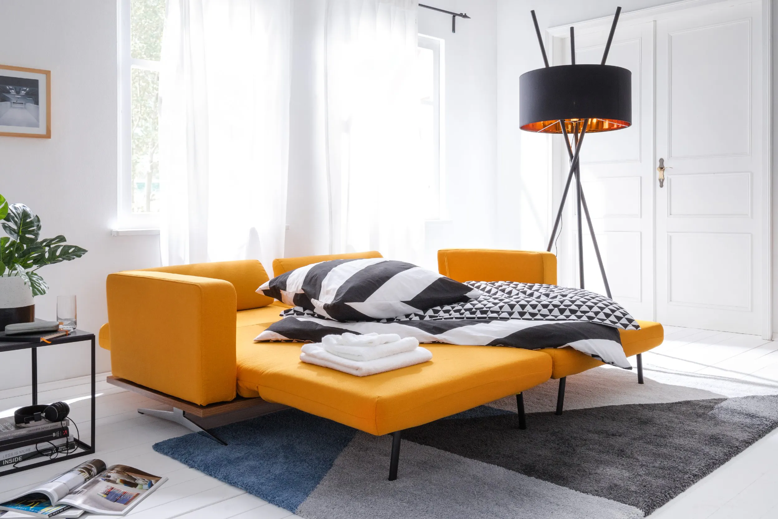 Oranje slaapbank met zwart-wit beddengoed