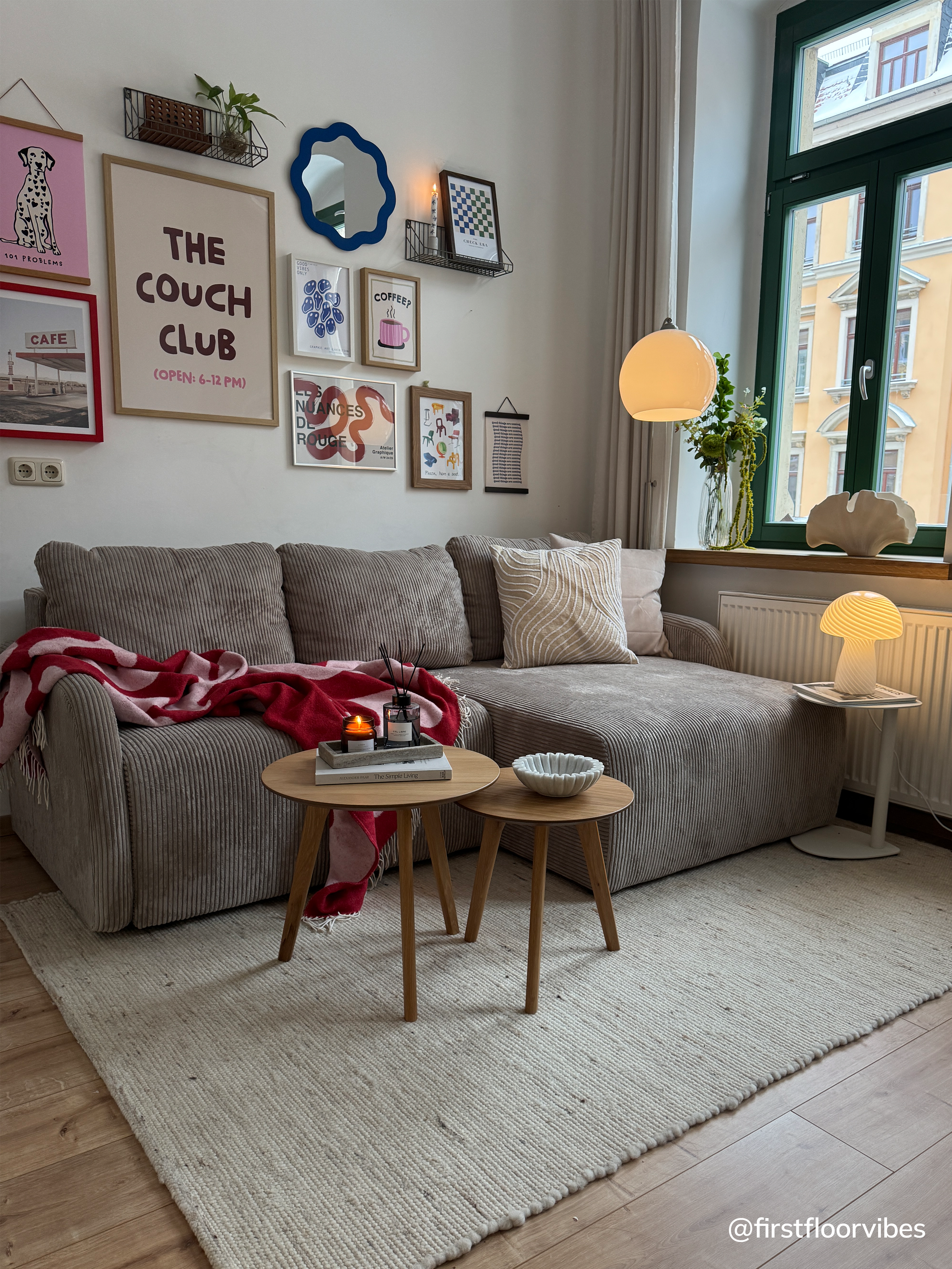 Graues, kleines Ecksofa aus Cord mit bunten Bildern und Holzbeistelltisch-Set.