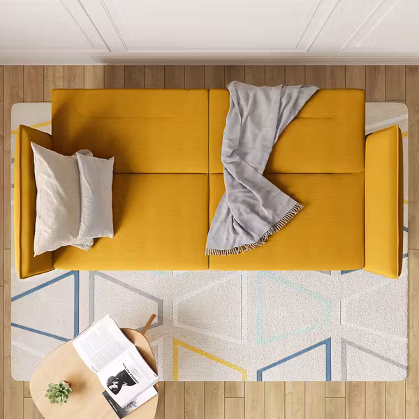 Ausklappbares, gelbes Schlafsofa mit weißen Kissen und beiger Decke.