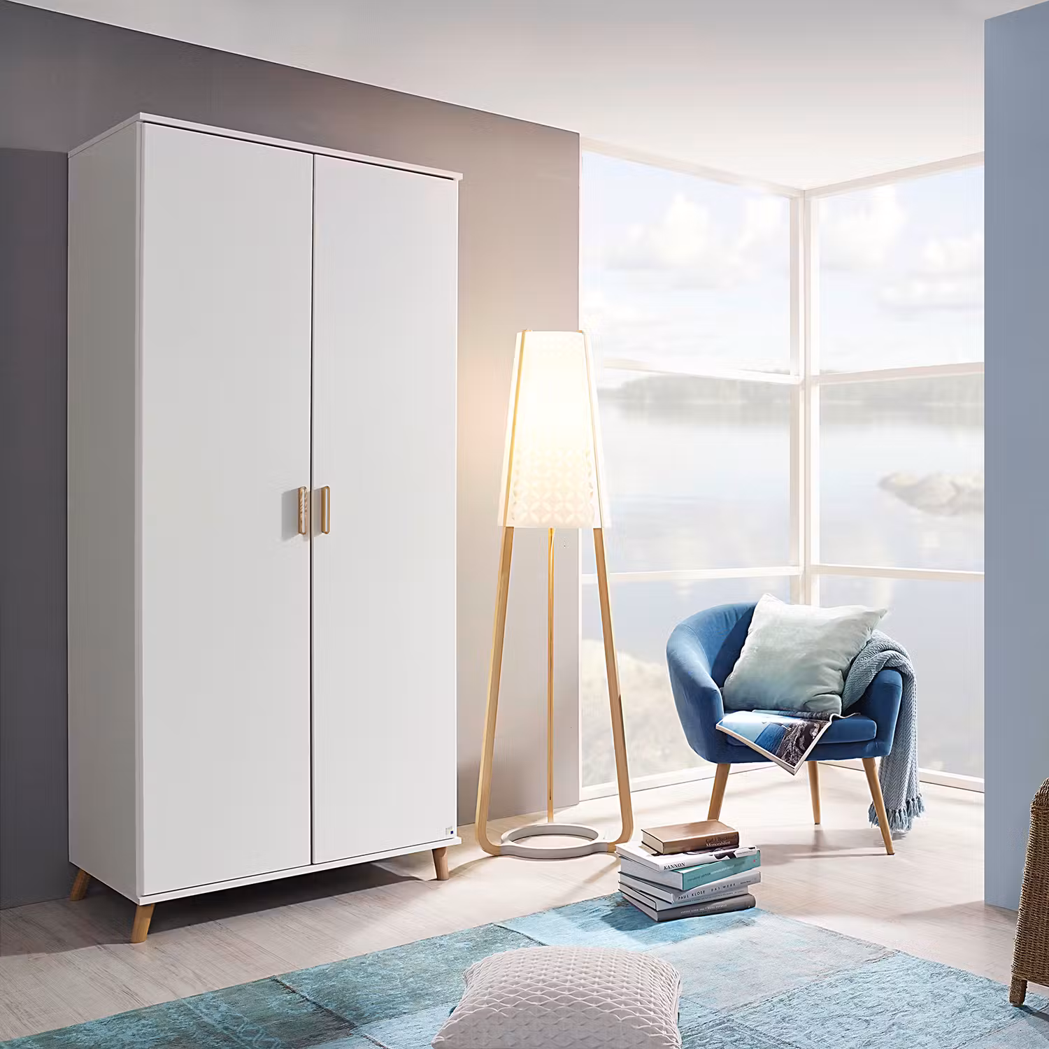 Weißer Kleiderschrank im Skandi-Stil mit stylisher Holzstehleuchte und einem schönen, blauen Sessel