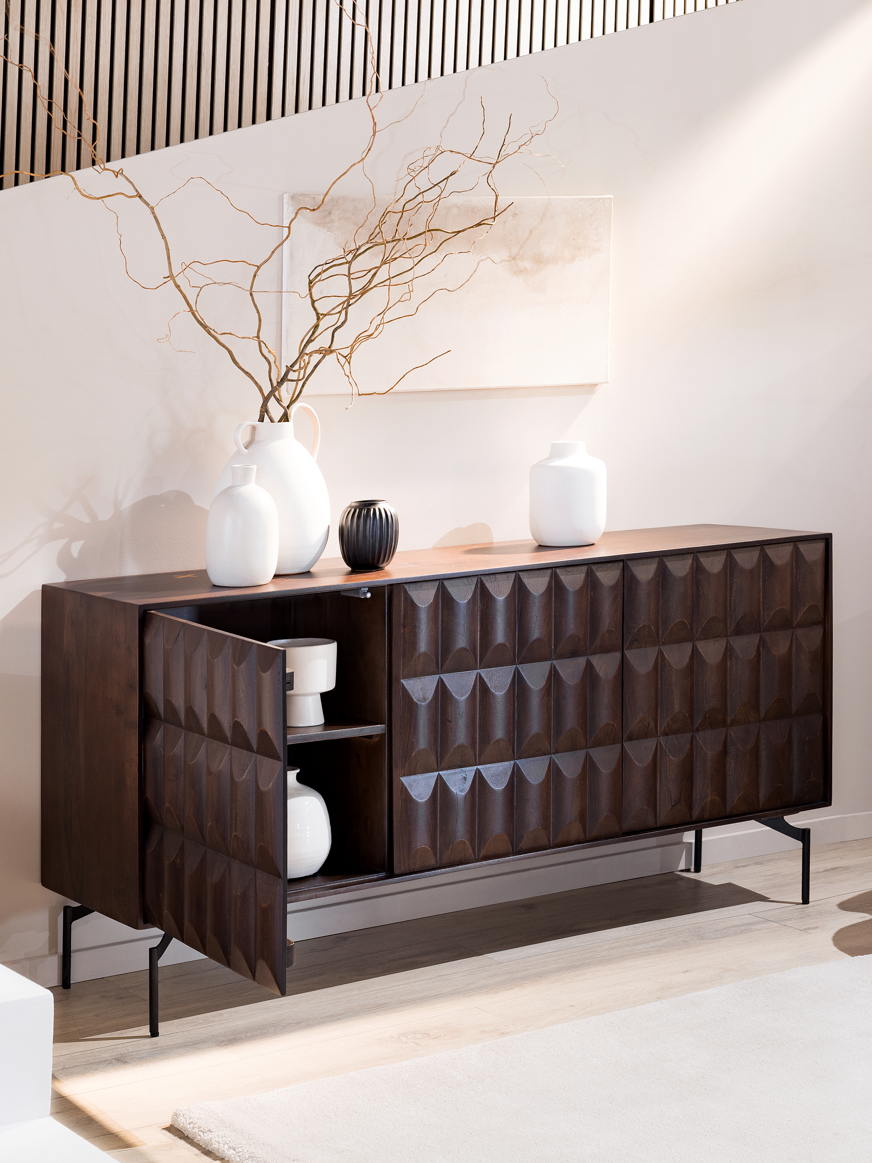 Sideboard aus dunklem Holz mit strukturierter Front und schlichter Deko.