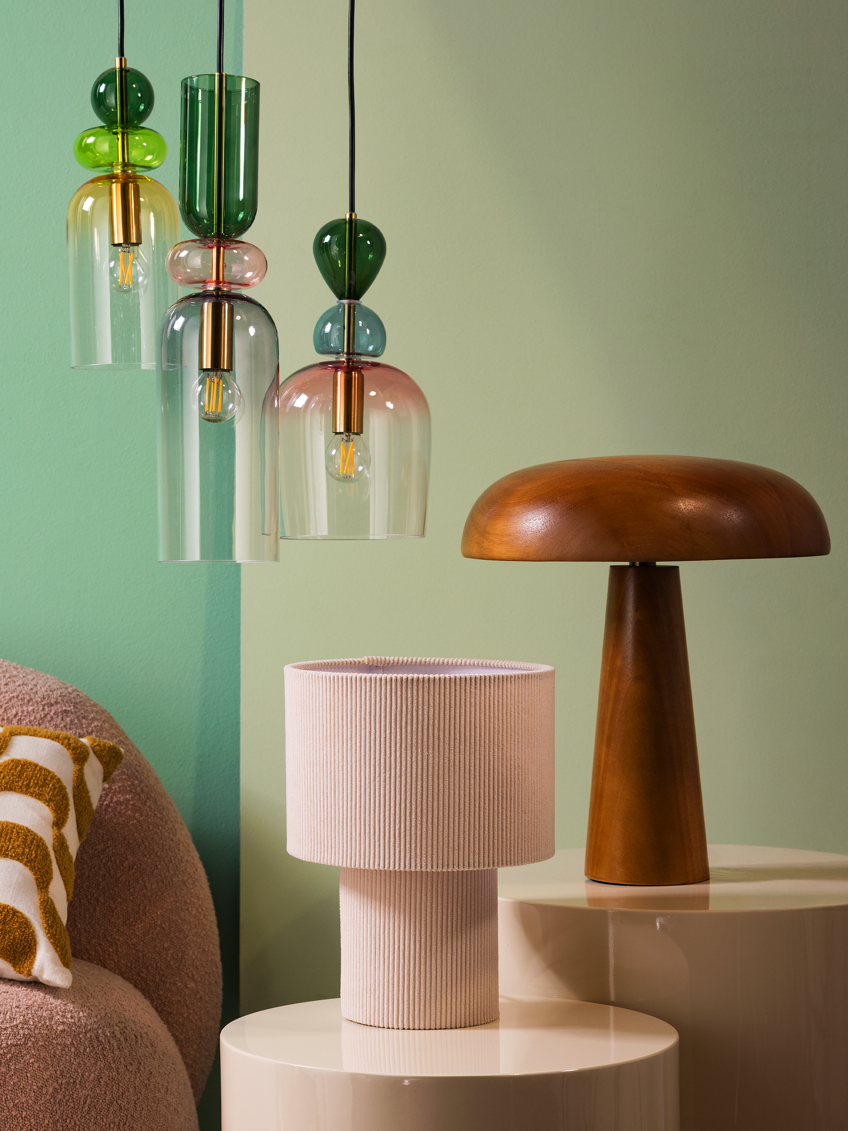 Set aus Hänge- und Tischlampen in Holz-, Textil- und bunter Glasoptik.